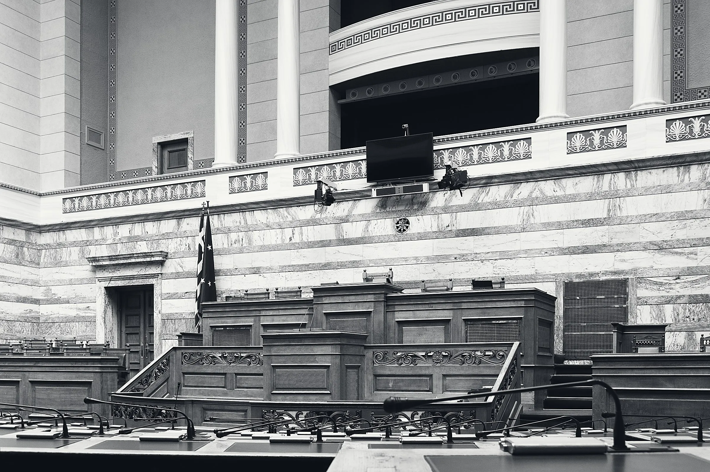 Η αίθουσα της Ολομέλειας της Βουλής, άδεια, σε ασπρόμαυρη φωτογραφία.